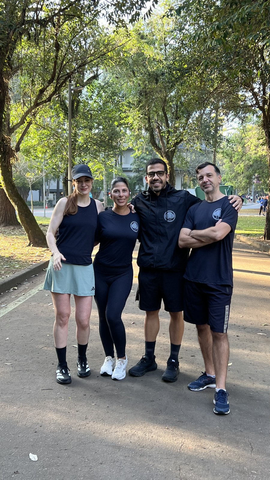 Alunos e prof. Nicolas abraçados na pista do parque em manhã de sol