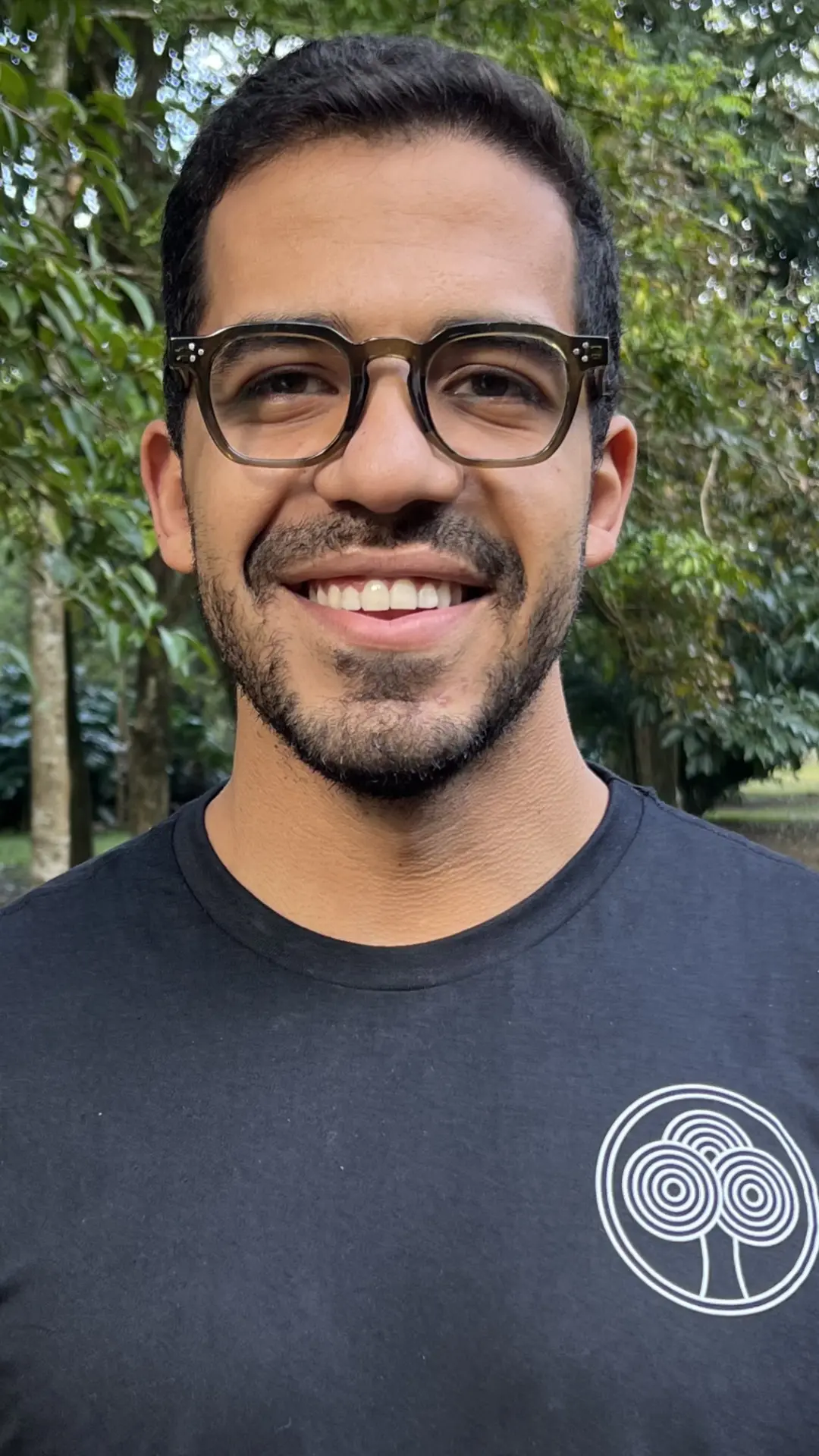 Retrato do prof. Nicolas Camillo em pé num parque, com expressão tranquila